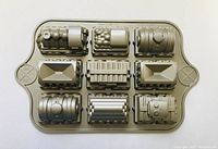 Top view of cake pan showing nine molds shaped like train cars and engine with detailed features.