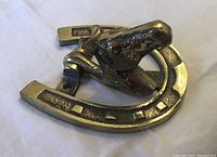 View of the side angle showing the horse head mounted within the horseshoe and knocker hinge.