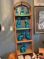 Front view of bamboo shelf unit with decorative turquoise ceramic figurines (not included). Shelf has a natural bamboo finish with 4 shelves and an open back.