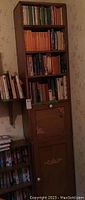 Full view of the assembled two-piece wood cabinet filled with books and other items