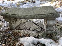 Front view of the curved concrete garden bench showing decorative edging and leg details.
