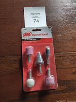 Front view photo of Ingersoll Rand die grinder stones set in original packaging on wooden surface, showing 5 abrasive stones mounted on metal shanks.