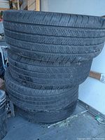 Stack of four Michelin Defender LTX M+S tires showing minimal tread wear, side view.