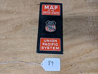 Front cover of folded Union Pacific System map, black with orange and white text and logo, showing 'MAP OF THE UNITED STATES' and Union Pacific shield.