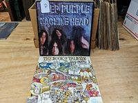 Both Deep Purple LP records Machine Head and The Book of Taliesyn set standing upright on a wooden surface showing album cover fronts