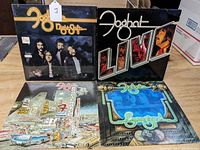 Four vintage Foghat LP vinyl albums arranged standing and flat: Night Shift, Live, Boogie Motel, and Energized, showing front covers with some edge and corner wear.