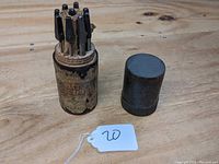 Original assembled view of canister with lid off showing drill bits inside.