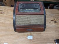 Front view of antique Philco radio/phonograph with dial and fabric speaker covering.