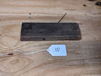 Top view of the wooden molding plane on a wooden surface with a white string tag labeled '10'.