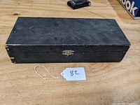 Closed black presentation case with metal clasp for the Master Violet Ray No. 9 device.