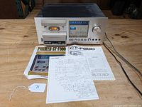 Front view of Pioneer CT-F900 cassette player with instruction manuals and schematic paper placed in front on wood surface