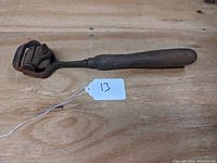 Full view of vintage cabinet box scraper showing wooden handle and metal scraping head with rust patina.