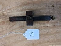 Full view of the vintage exotic wood woodworkers scribe gauge showing the wooden body, sliding block with thumb screw, and metal scribing pins.