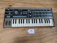 Full front view of Korg MicroKorg showing wood side panels, keybed, control panel and missing tags