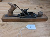 Side view of the vintage Stanley No. 27 woodworking plane showing wooden base and rear pistol grip handle