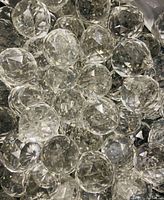 Clear faceted crystal orbs arranged together, showing spherical shapes with multiple facets for light reflection.