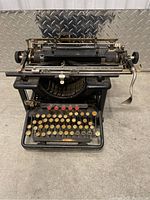 Front view showing keys, typebars, and brand name Remington Standard in yellow on the front.