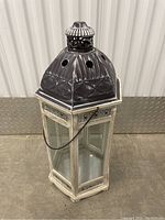 Large garden lantern showing front view with glass panes and vented metal top