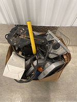 Overview of a cardboard box packed with multiple power tools and cables, showing the overall contents and condition.