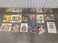 Full layout of 14 vintage Disney ephemera items from 1930s to 1980s, including sticker albums, calendars, booklets, and cutouts.