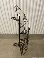 Full side view of the vintage metal spiral garden stair planter stand showing height and overall structure.