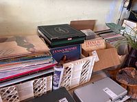 Two crates and two boxes filled with vintage vinyl records. Some album covers are visible including Diana Ross, Donna Summer, and Olivia Newton-John.