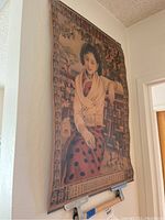 Asian paper artwork showing a woman in vintage attire seated against a floral and geometric background