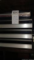 Stack of four silver Bang & Olufsen modules with plastic-wrapped top unit
