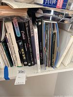 Books arranged upright on a shelf showing a variety of gardening and orchid related titles including English and Asian language books.