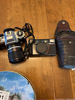 Overview of Nikon FG SLR with zoom lens, Nikon AF compact camera, and leather Nikon case
