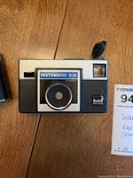 Front view of Kodak Instamatic X-15 camera on table, showing lens, viewfinder and branding