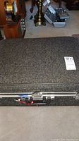 Closed vintage cloth suitcase with metal edges and latch closure