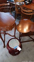 Photo showing three wooden tables: one ornately carved, one kidney-shaped, and one small round stool with marble top.