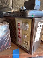 Side view of one vintage Panasonic radio with Chinese characters on front panel, tuning and volume knobs and band/tone switches visible