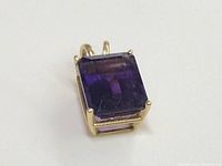 Close-up side angle showing pendant's 14k gold setting around rectangular amethyst gemstone