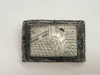Front view of rectangular sterling silver pin with ivory panel showing woman and child in traditional clothing in interior setting.