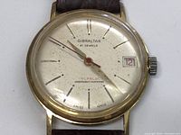 Front view showing dial, brand name, date window, and hands.