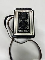 Front view of Spartus Full-Vue twin lens reflex camera with black body and silver front plate.