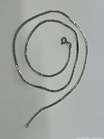 Sterling silver chain laid flat to show overall length and shape with spring ring clasp visible.
