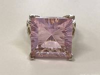 Front view of sterling silver ring with large square pink faceted gemstone polished and showing inner reflections.