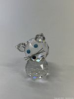 Front view of the Swarovski crystal mouse figurine showing blue eyes, clear faceted crystal body, and black nose with metallic whiskers.