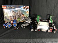 Overall view showing Harry Potter set box, two Technic vehicles, and assorted LEGO pieces.