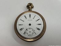 Front view of Waltham pocket watch showing white dial with Roman numerals, 24-hour markings, and small seconds subdial.