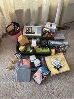Overview of basket filled with sunglasses, small boxes, figurines, and decorative items on carpet.