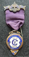 Front view of 1910 sterling silver hallmarked Freemason jewel medal with purple ribbon and enamel decorations.