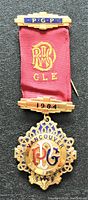 Front view of the 1984 Vancouver Freemason type jewel medal with gold-tone metal, red fabric ribbon, and inscriptions PGP, R M GLE, and 1984.