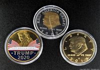 Front sides of three Trump tokens, gold and silver plated, details of text and profile images.