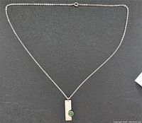 Necklace laid out flat showing full chain and pendant against a dark background.