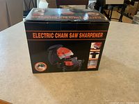 Box of electric chain saw sharpener showing product name and image on the side.