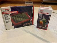 Two boxed items on a white sheet: TRD Sport Parts Performance Air Filter and TRD Sport Parts Filter SpeedClean Kit.